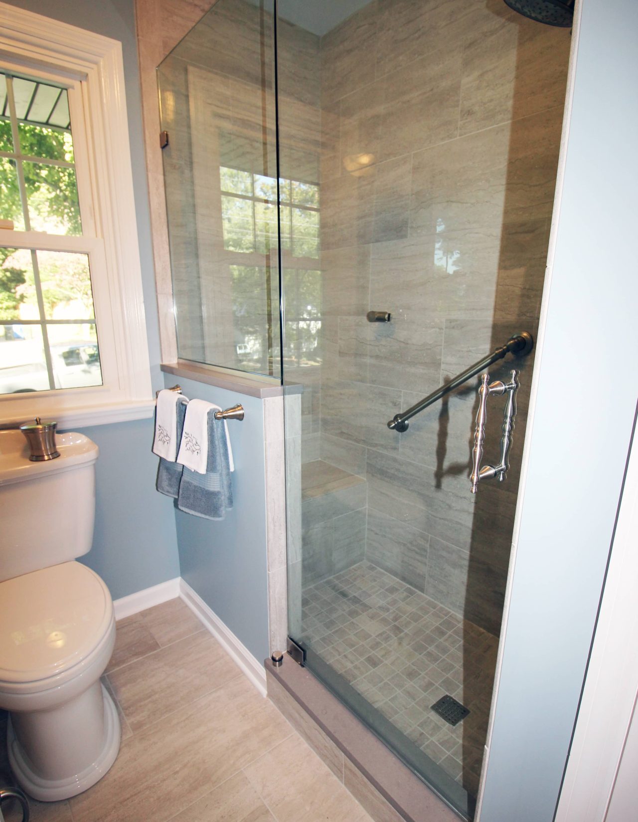 renovated bathroom with glass shower door and tiled shower walls