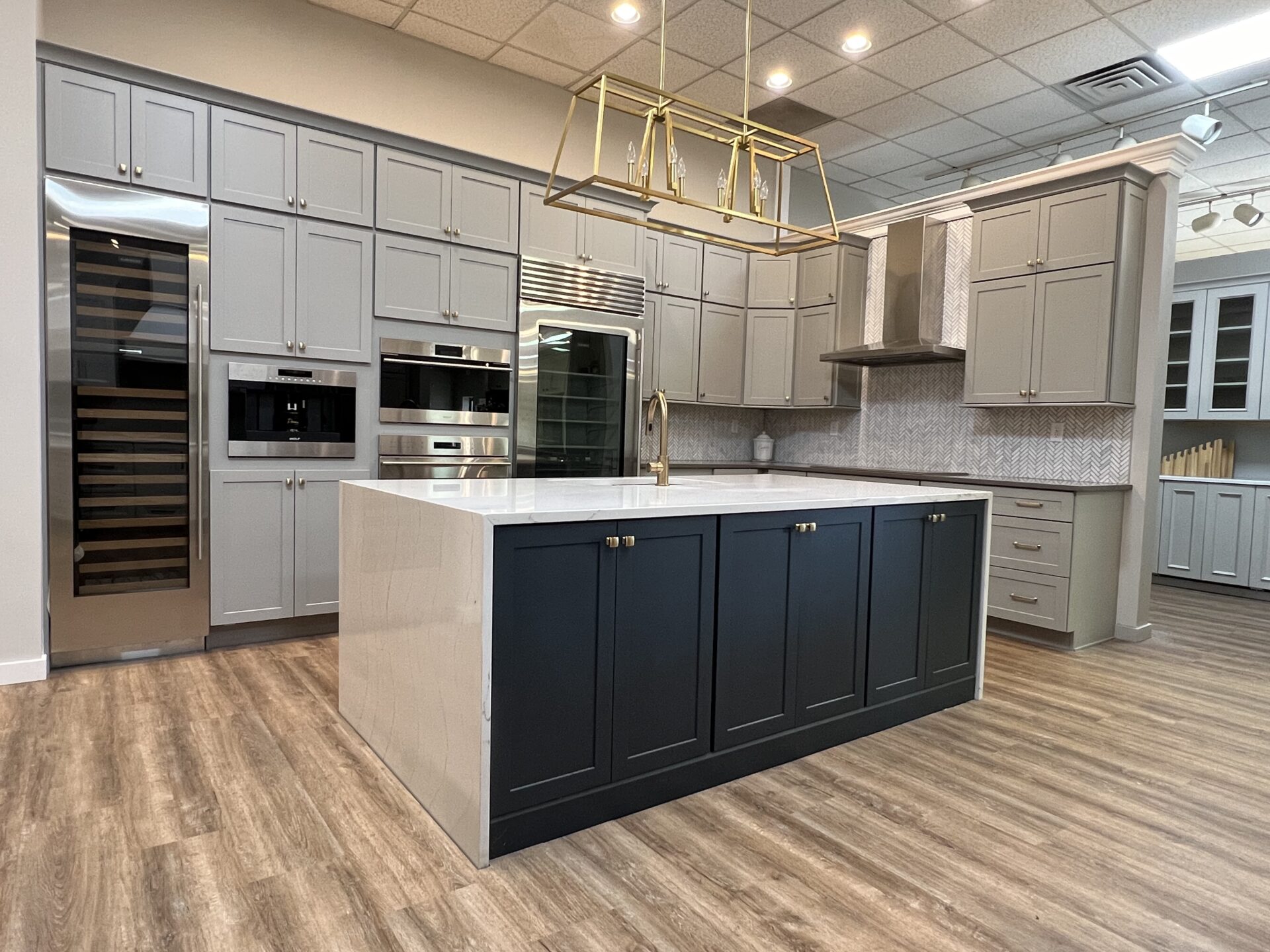 BKT Wilmington De Showroom modern kitchen with navy island with gray cabinets and white countertops