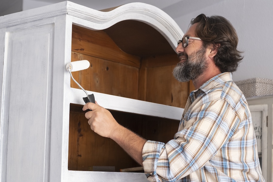 man painting kitchen cabinets
